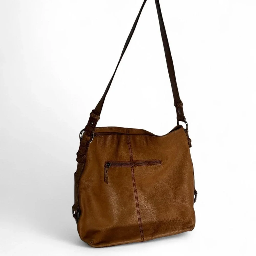 Tan leather shoulder bag with zipper closure, multiple pockets & braided tassel